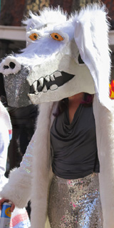 A lady wearing a glam Falcor mask and costume.