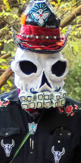 A man in a skeleton cowboy mask and hat.