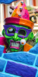 A guy in a green zombie mask with an eyeball dangling out of its socket.